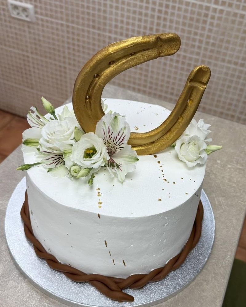 Tort aniversar cu potcoavă aurie și flori